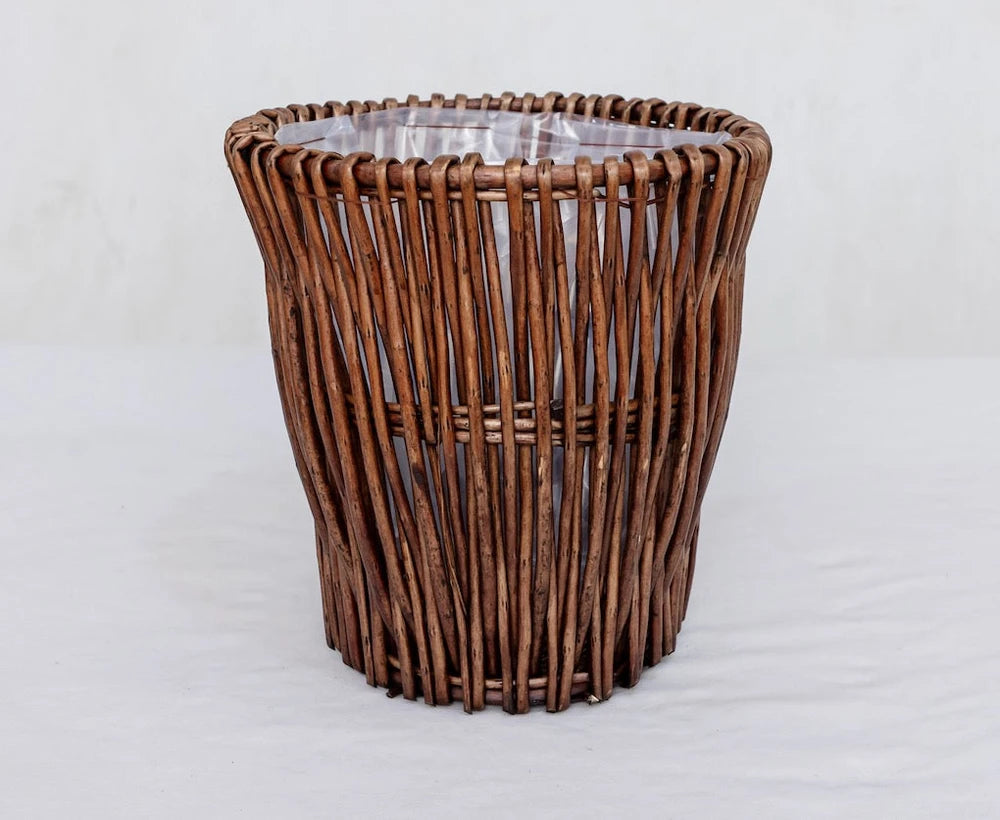 Handwoven wicker trash can with natural brown finish, ideal for cozy home decor and rustic bathroom or kitchen use.
