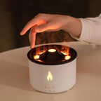 Flame-effect essential oil diffuser with warm glow and mist, hand adjusting settings on cozy tabletop