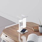 Modern white wireless charger with phone on wooden bedside table, minimalist home decor