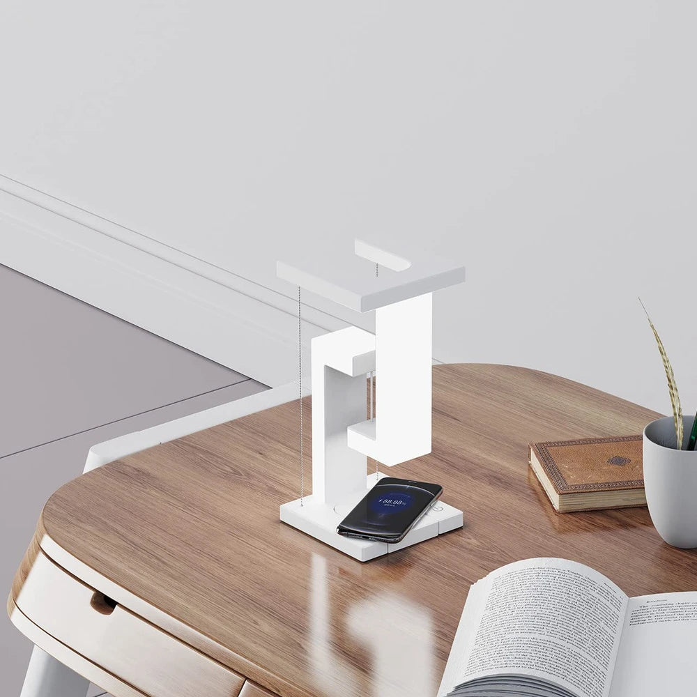 Modern white wireless charger with phone on wooden bedside table, minimalist home decor