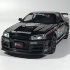 Black diecast sports car model with racing decals, detailed grille, and spoiler on white background
