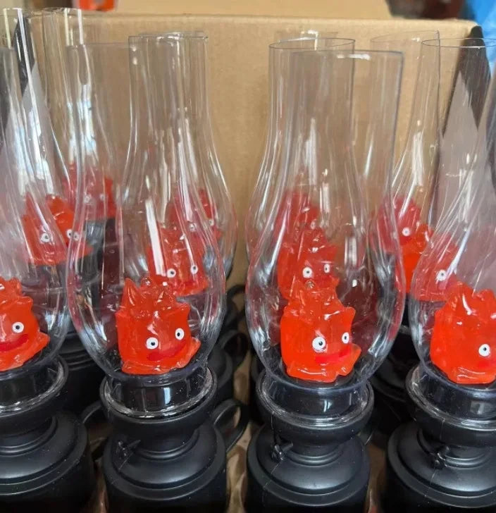 Red monster figurines inside clear glass lamps with black bases, cute decorative lighting