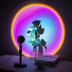 Colorful LED projector lamp casting rainbow circle glow on wall with flower vase, book, and mug on desk