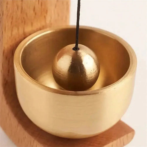 Brass singing bowl with mallet on wooden stand, meditation & relaxation tool