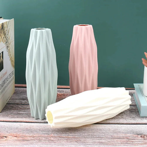 Modern ceramic vases in mint, blush, and cream with geometric ridges, styled on rustic wood for home decor