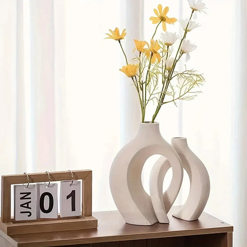 Modern white ceramic vase with yellow and white flowers, wooden calendar on shelf, minimalist home decor