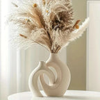 Modern ceramic vase with dried pampas grass and white blooms, minimalist home decor accent