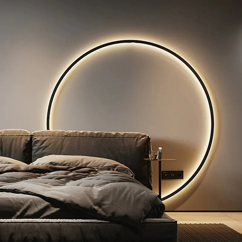 Modern circular wall light with warm glow above bed in cozy bedroom setting