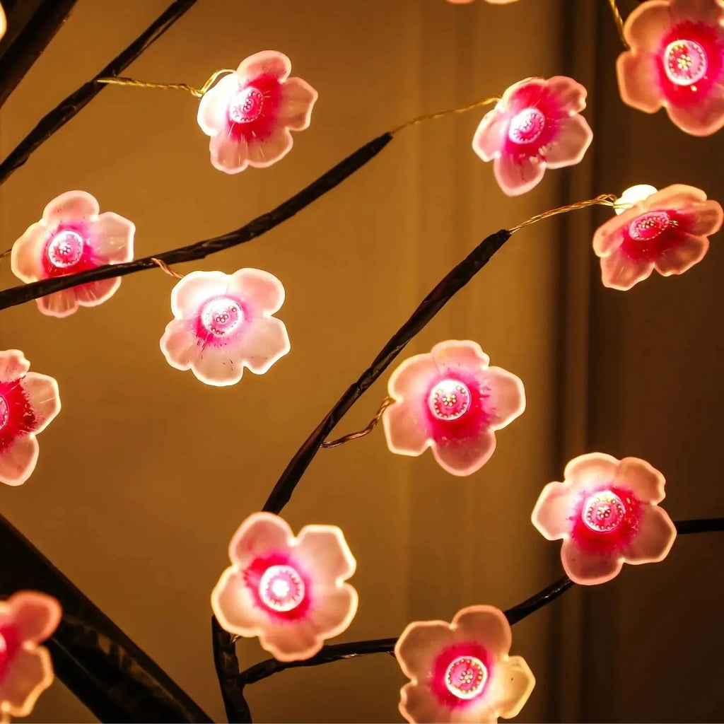 Glowing pink cherry blossom string lights on dark branches, cozy ambient home decor