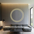 Modern living room with circular LED wall light, gray sectional sofa, and wood panel accent wall