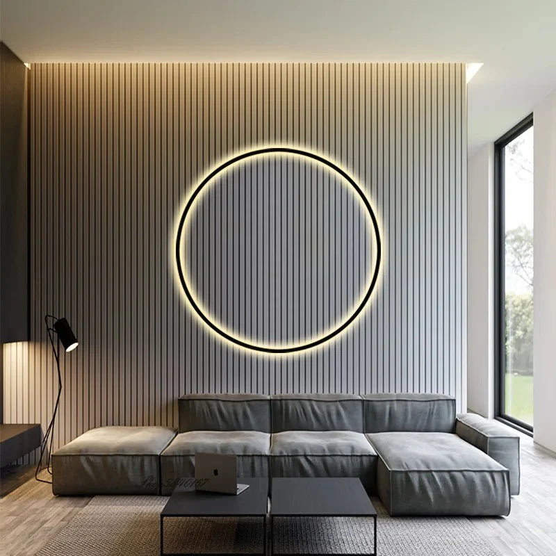 Modern living room with circular LED wall light, gray sectional sofa, and wood panel accent wall