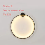 Modern circular wall sconce with warm glow, black frame, requires hardwired installation