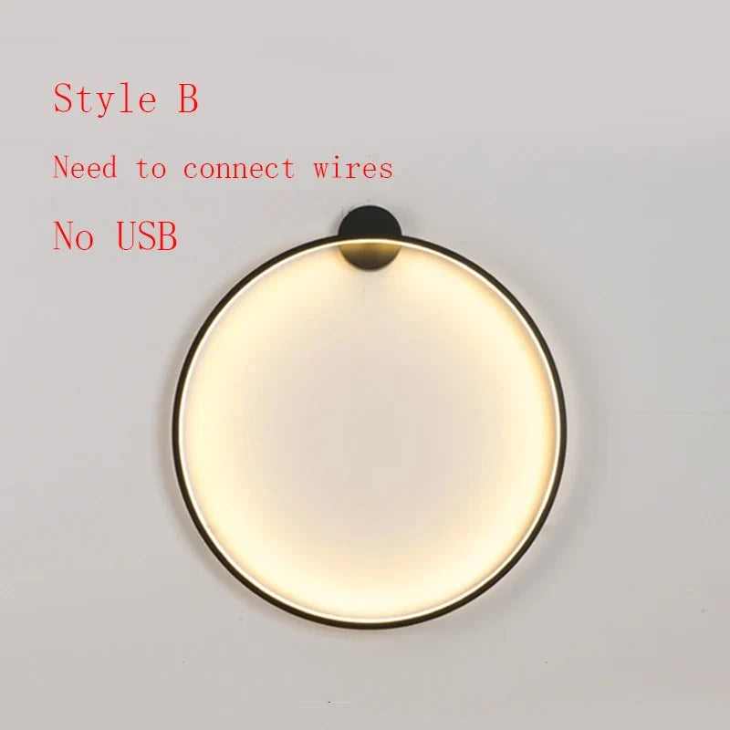 Modern circular wall sconce with warm glow, black frame, requires hardwired installation