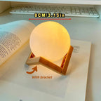 8cm glowing moon lamp with wooden bracket on open book, cozy desk decor