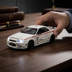 White sports car model with red stripes, detailed decals, and illuminated headlights on wooden desk